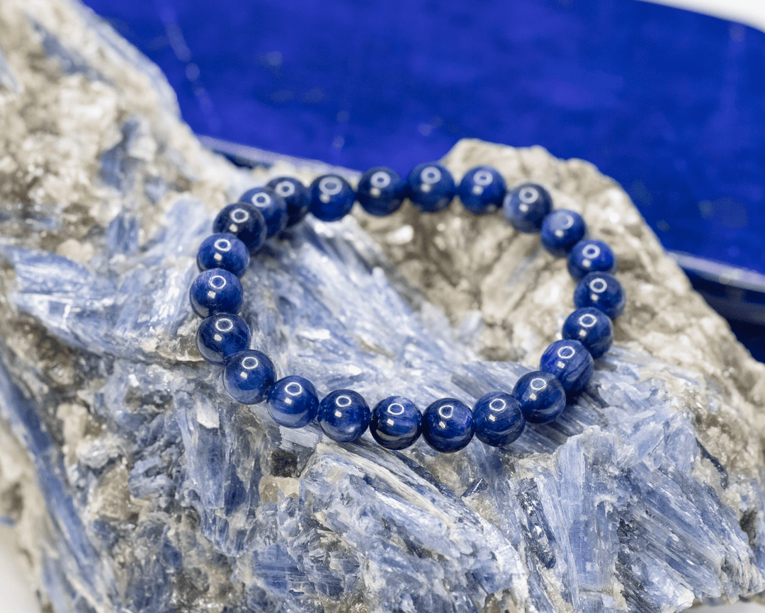 Blue gemstone stretch bracelet displayed on a blue-and-white mineral specimen