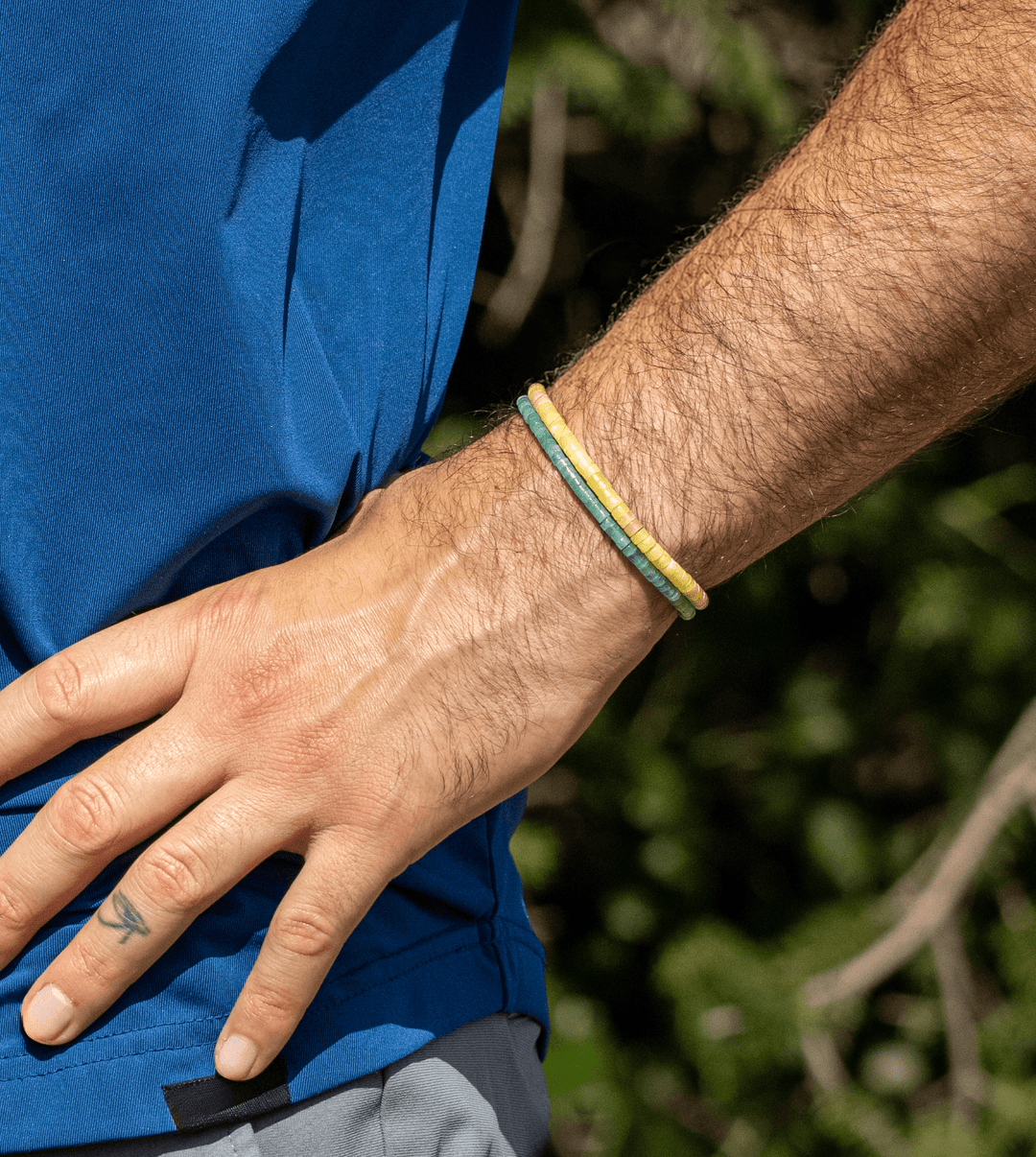 Amazonite Heishi bracelet stacked with yellow and green bracelets on a wrist outdoors