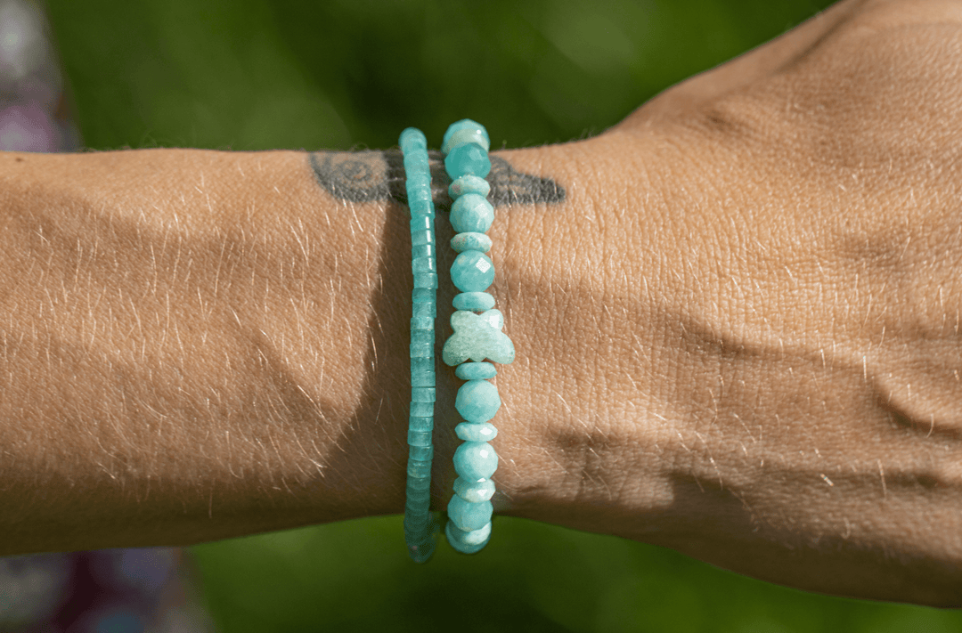 Amazonite Heishi bracelet stacked with a chunky aqua bracelet on a tattooed wrist outdoors
