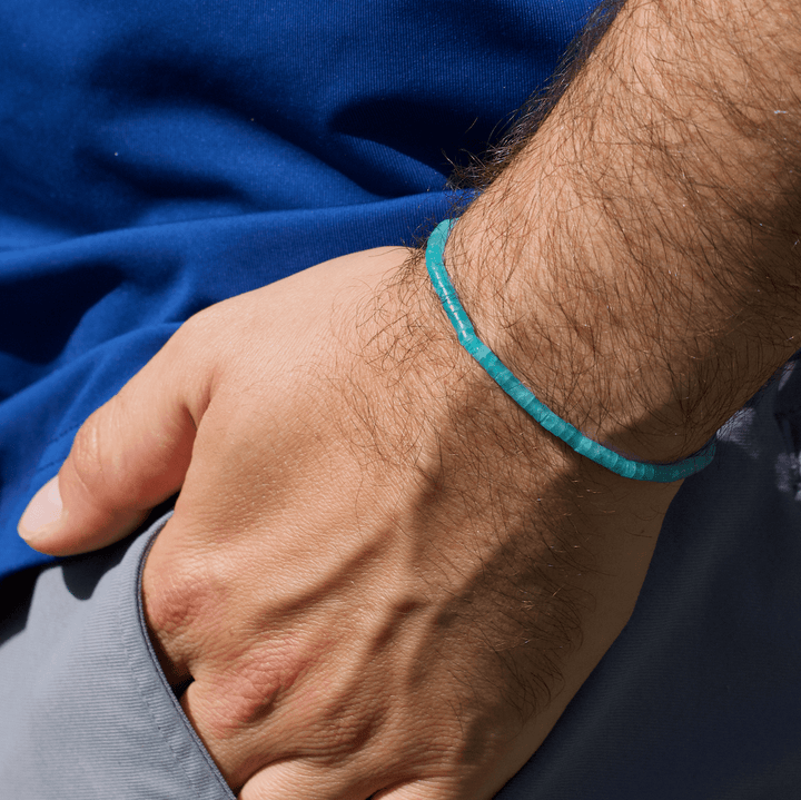Amazonite Heishi bracelet worn alone on a wrist beside a bright blue shirt