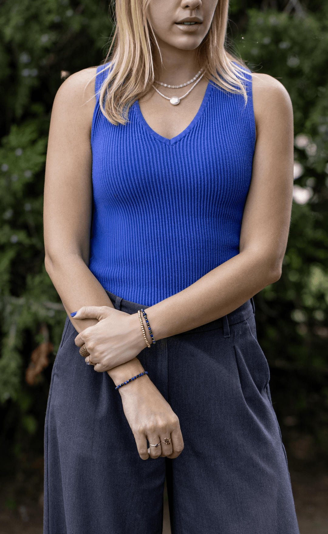 Earthrise bracelet worn on one wrist and paired with a gold-tone bracelet on the other outdoors