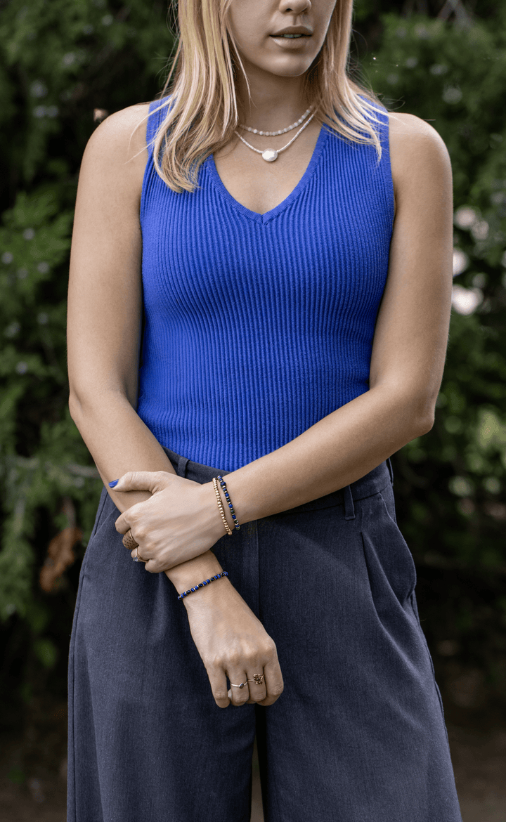 Earthrise bracelet worn on one wrist and paired with a gold-tone bracelet on the other outdoors