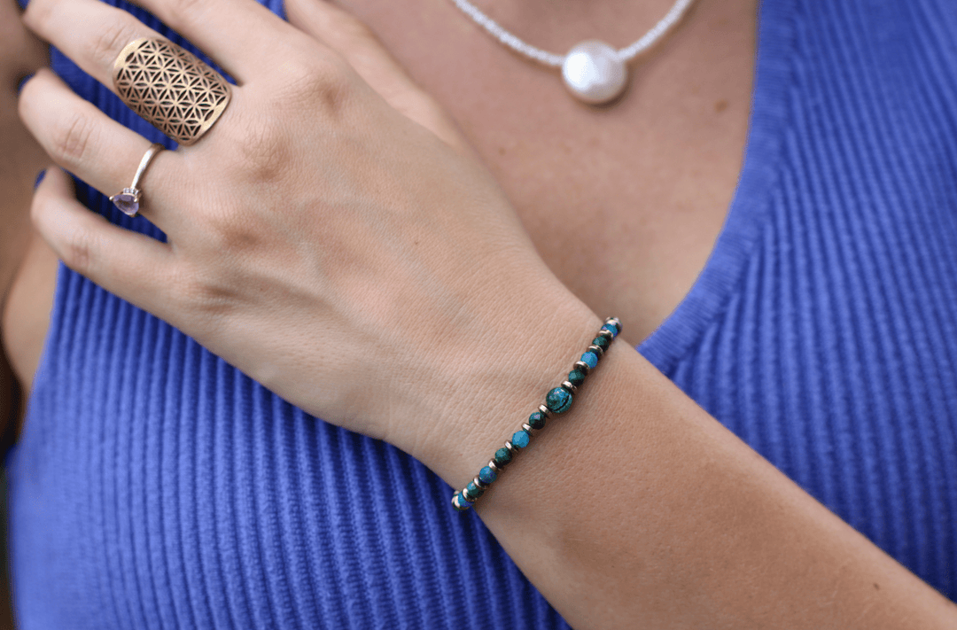 Earthrise bracelet worn alone on a wrist against a blue top outdoors