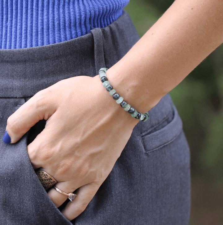 Ivy green chalcedony and kyanite bracelet on a wrist beside a blue top