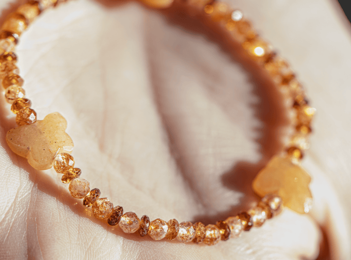 Monarch bracelet with orange gemstones and aventurine butterflies arranged on a seashell