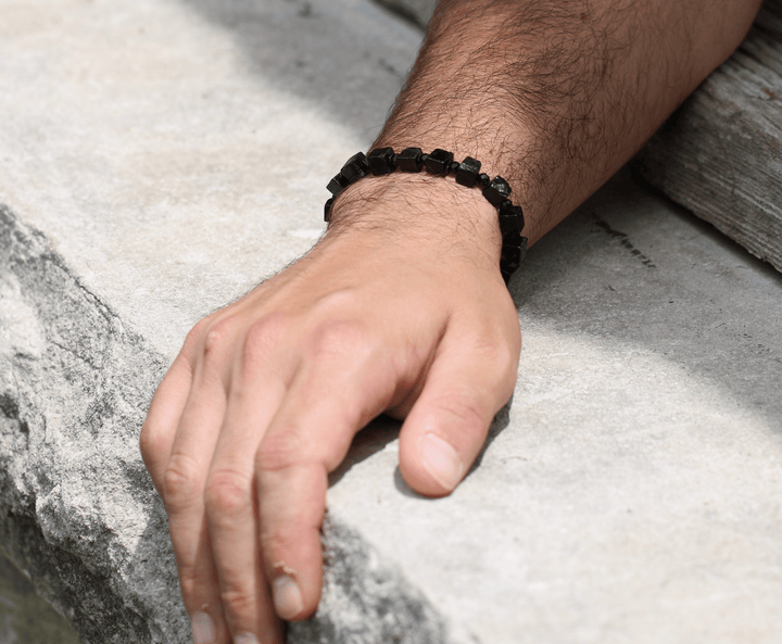 Paint It Black mixed-cut black tourmaline bracelet on a wrist resting on stone