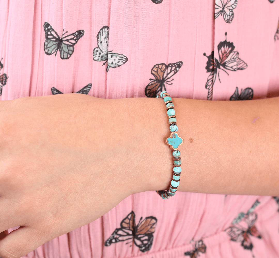 Patina Clove bracelet close-up showing turquoise beads and clover centerpiece on a wrist