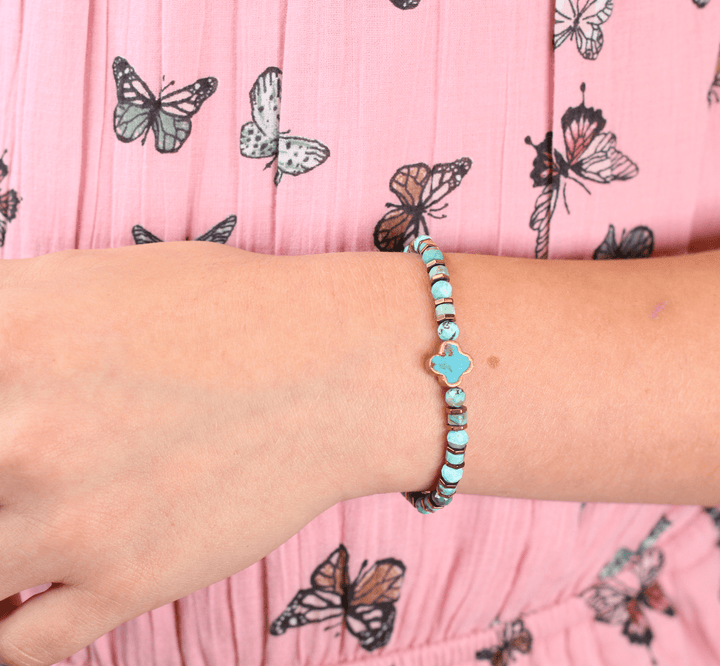 Patina Clove bracelet close-up showing turquoise beads and clover centerpiece on a wrist