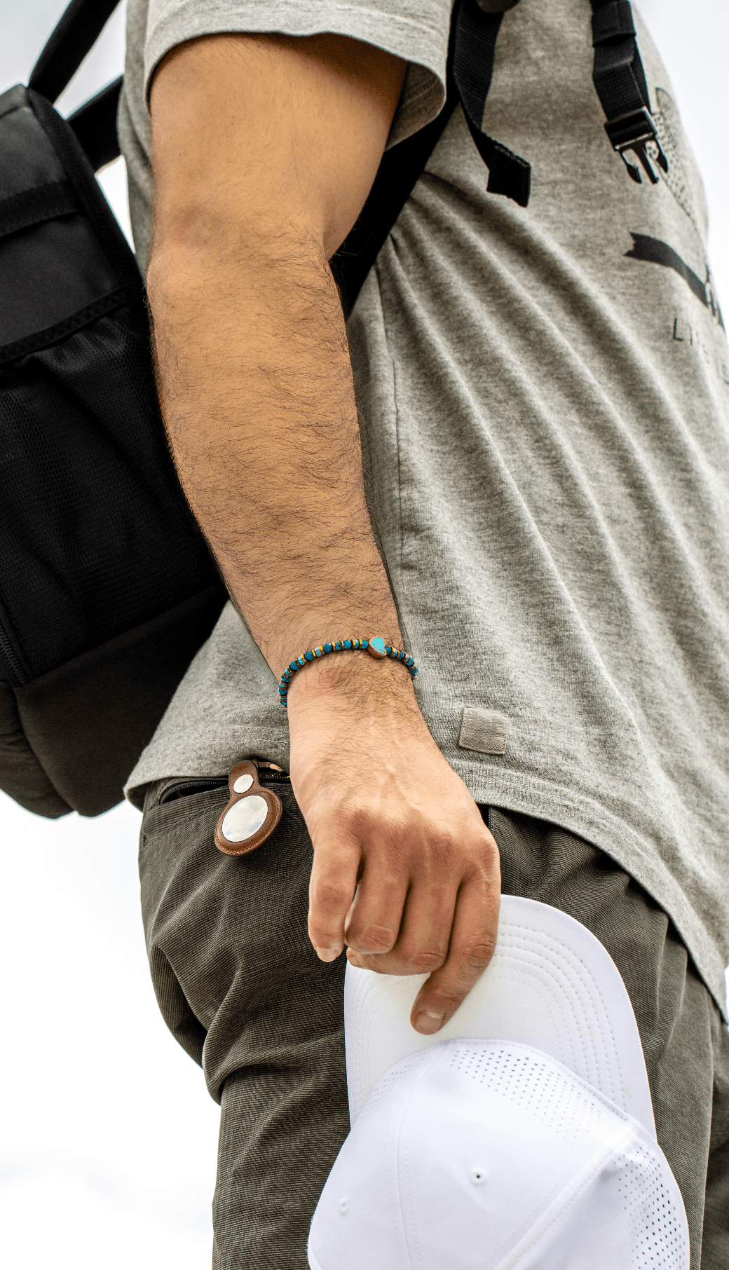 Patina Heart turquoise bracelet worn by a model carrying a white cap outdoors