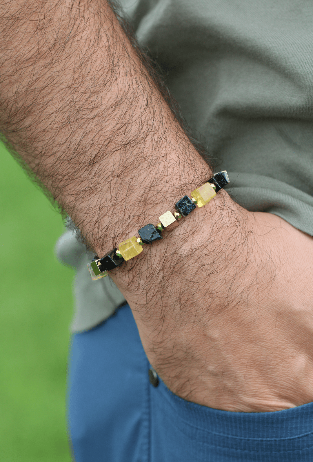 Shep black tourmaline and yellow fluorite bracelet on a model’s wrist outdoors