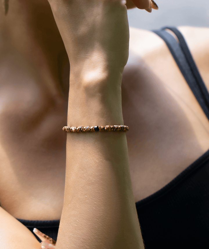 Tawny bronze biotite mica and titanium hematite bracelet on a raised wrist