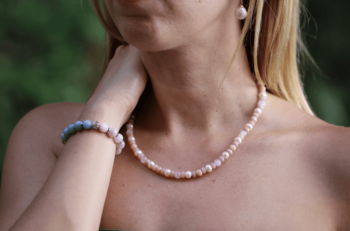 Teach kunzite and amethyst bracelet styled with a pink beaded necklace outdoors