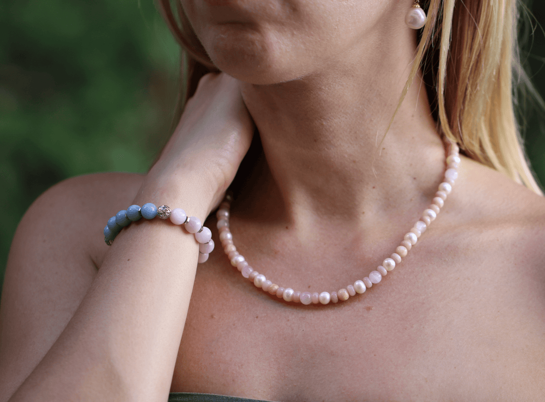 Teach kunzite and amethyst bracelet paired with a pink beaded necklace outdoors
