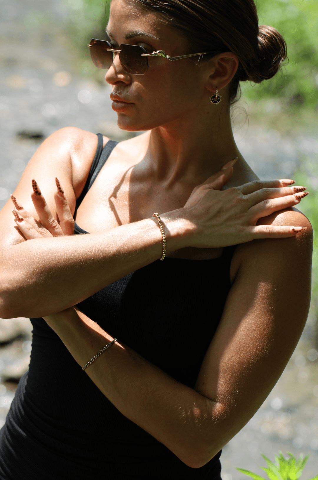 Titanium Hematite Rondelle bracelet on a raised wrist as a woman poses outdoors