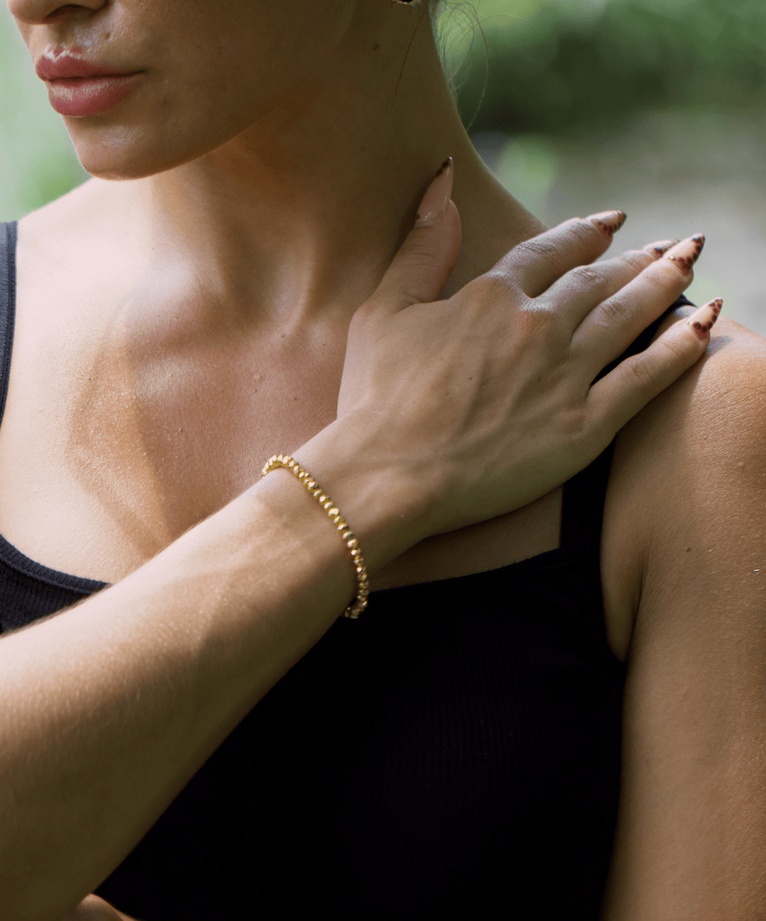 Titanium Hematite Rondelle bracelet on a wrist held across the shoulder outdoors