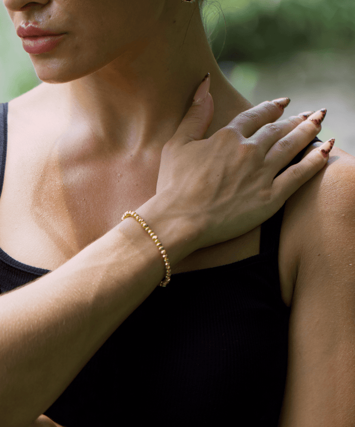 Titanium Hematite Rondelle bracelet on a wrist held across the shoulder outdoors