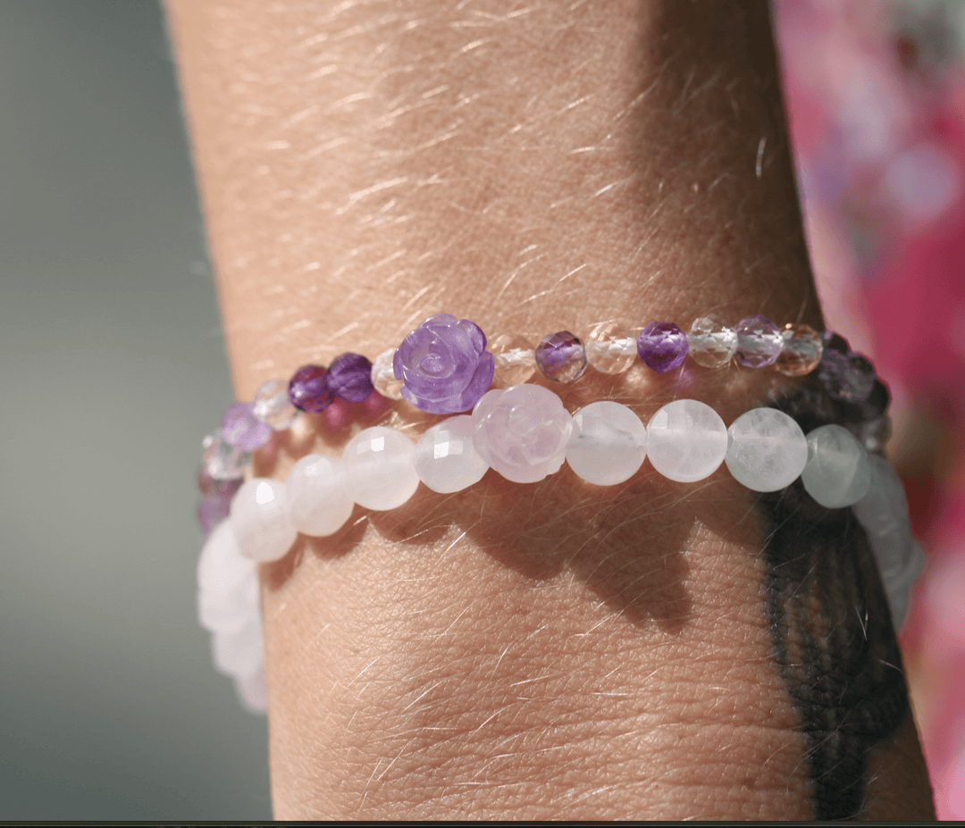 Viola purple amethyst bracelet stacked above a pale pink beaded bracelet on a wrist
