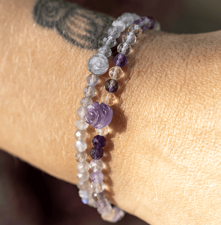 Silver Sage labradorite flower bracelet stacked with purple gemstones on a tattooed wrist