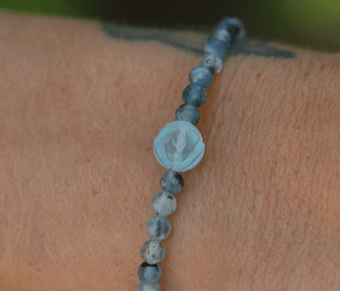 True Compassion aquamarine flower centerpiece and blue-gray beads in a wrist close-up