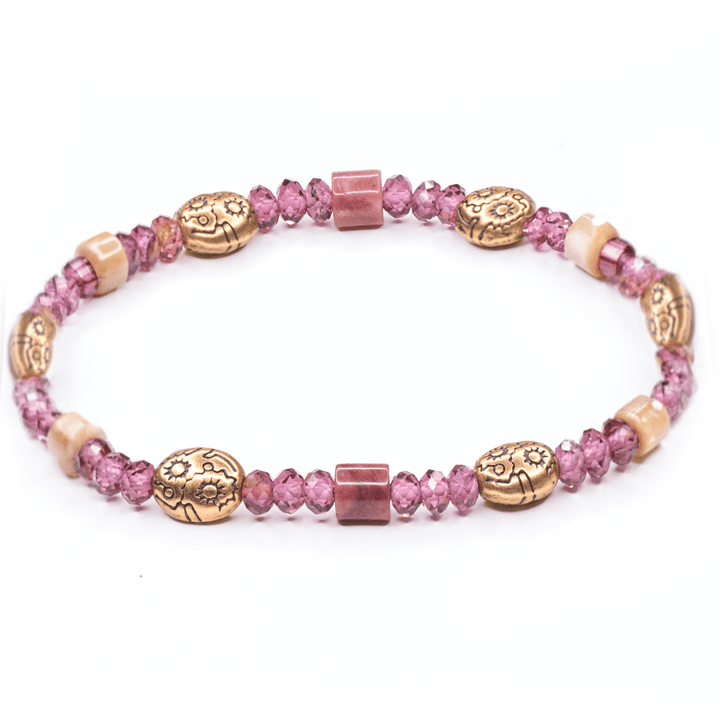 Willow garnet and petrified rhodonite bracelet with pink-purple beads and bronze-tone accents on white